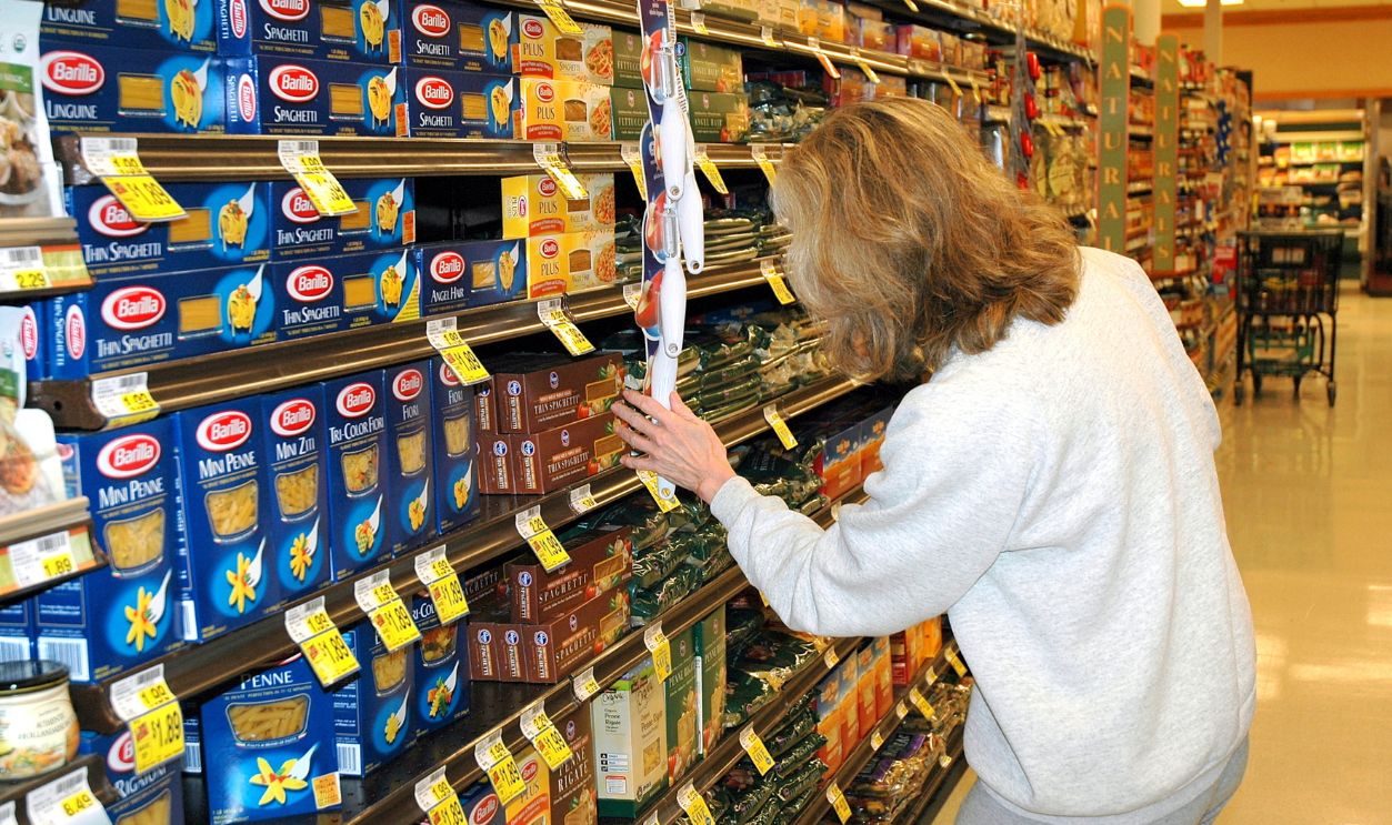 Shutterstock-584485342, OCTOBER 21, 2007. SEATTLE, WA.  CIRCA:  Mature female blond beauty shopping in a supermarket for food items.