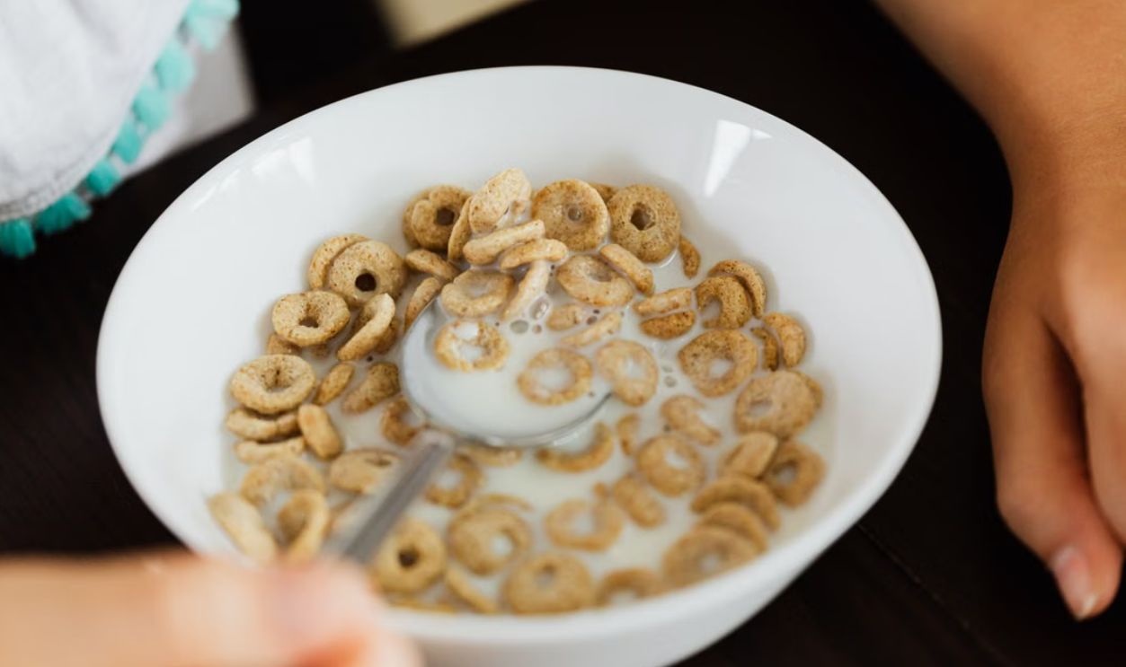 A close-up view of a bowl of cereal with milk, captured from above