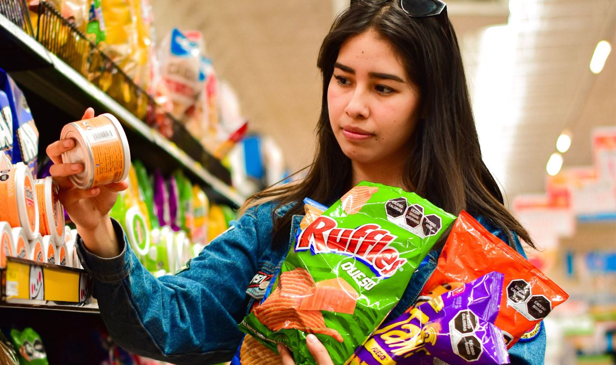 Woman selecting crisps in Texcoco, Mexico supermarket