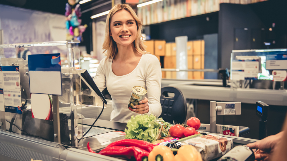 Beautiful young cashier in white top