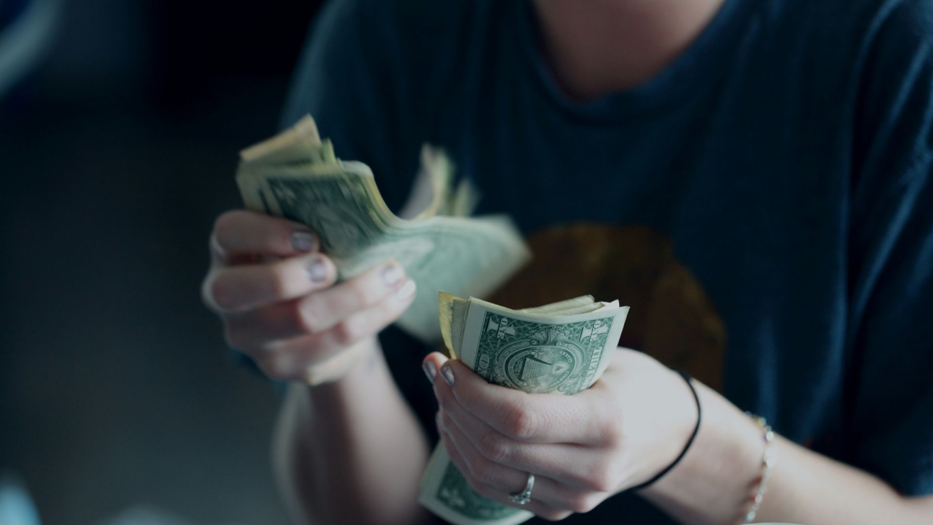 focus photography of person counting dollar banknotes