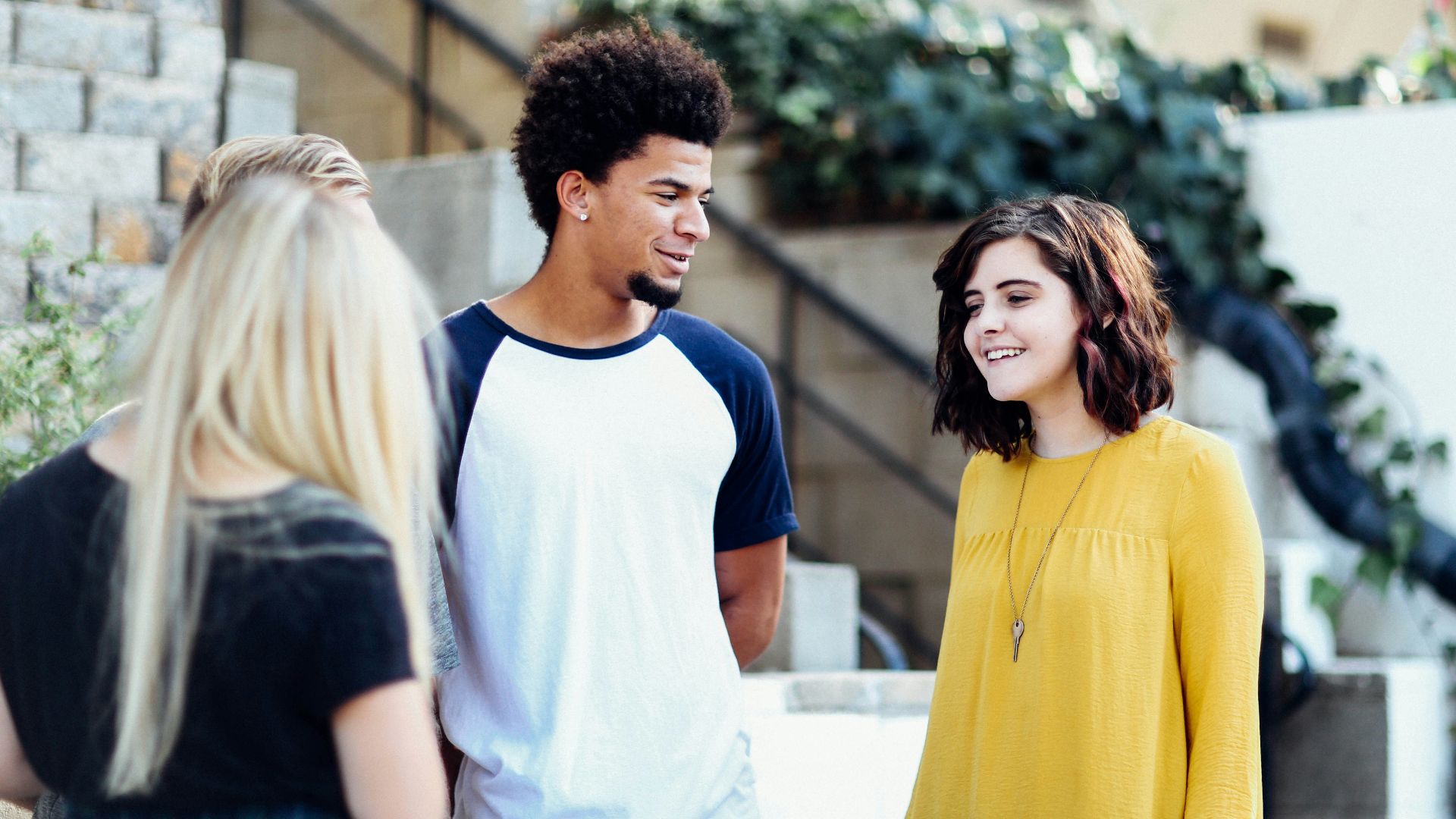 women and man talking outside the building
