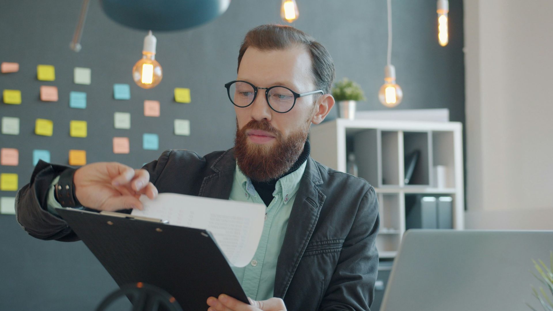 Man in glasses reviewing documents at desk
