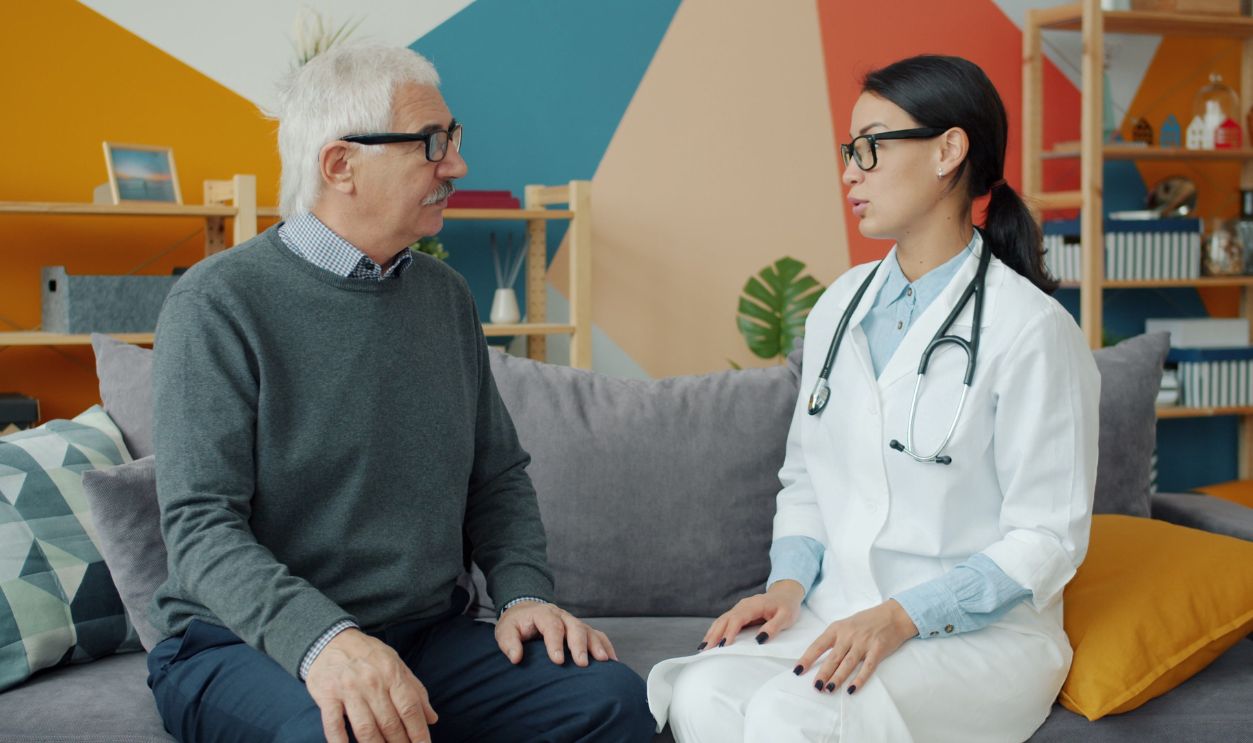 Senior man consulting with female doctor in a colorful office
