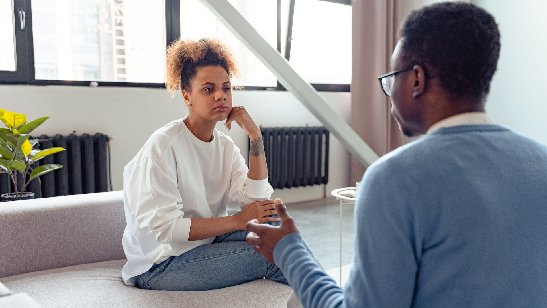 Couple arguing sitting on a sofa at home