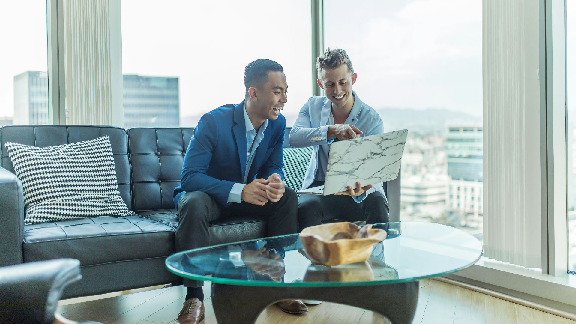 two men in suit sitting on sofa