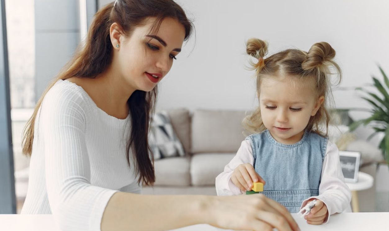 A mother and daughter bond while playing with educational toys indoors.