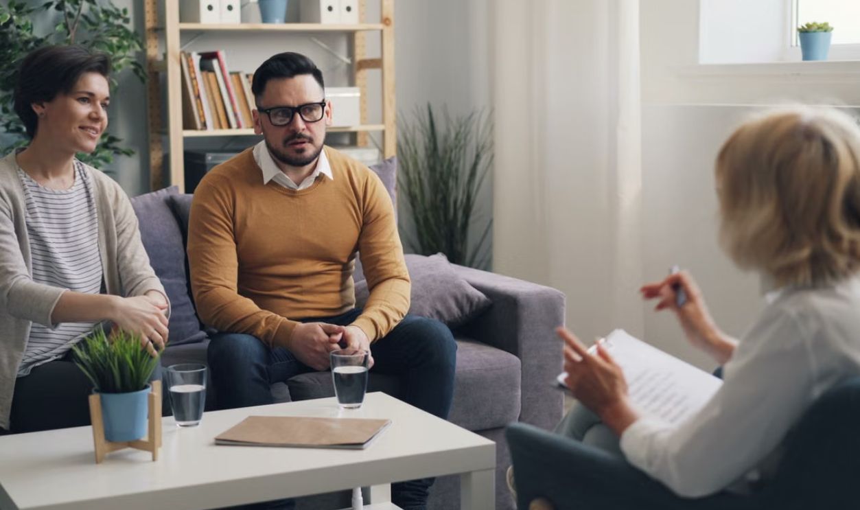 Couple discussing issues with therapist during a counseling session in a cozy office