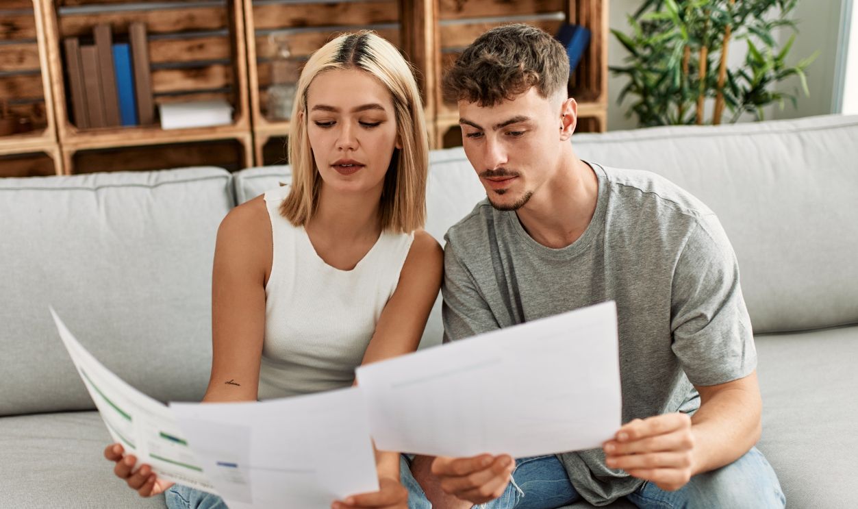 Young caucasian couple with serious expression controlling family economy using laptop at home.