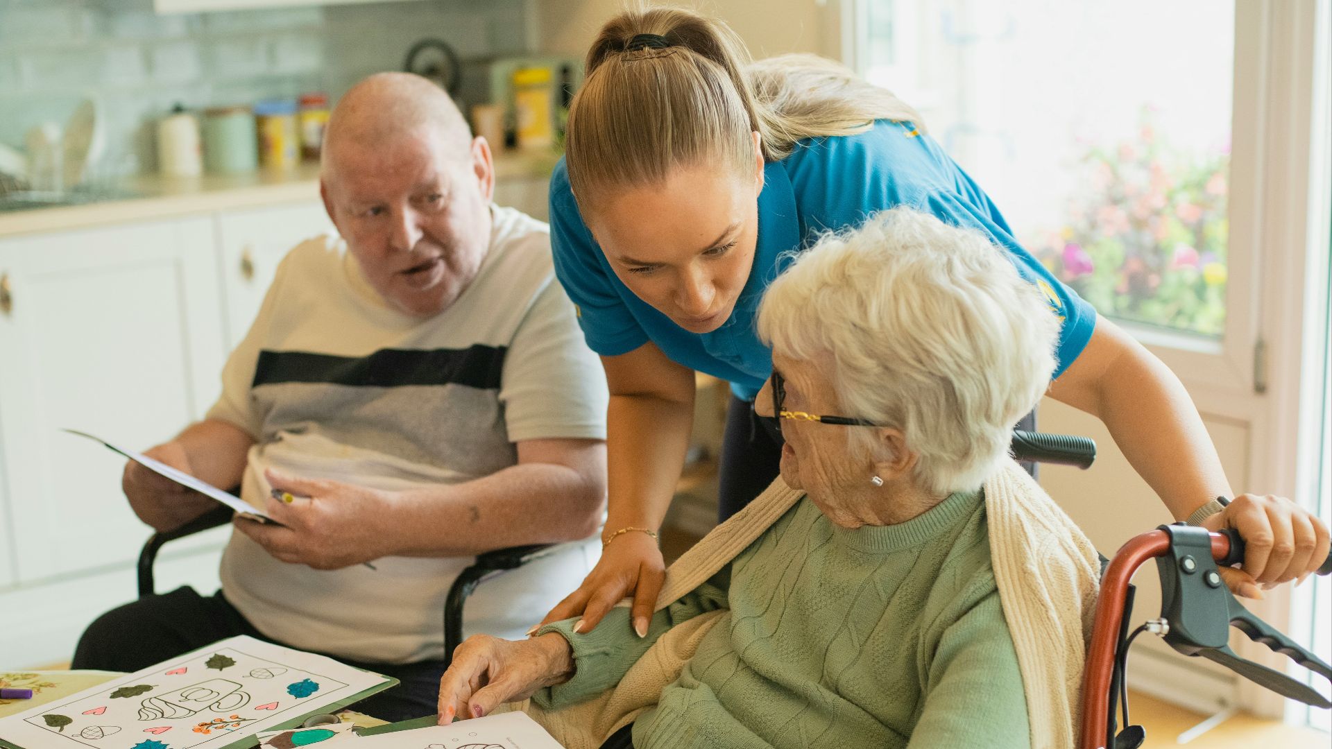Caregiver assisting elderly couple with coloring