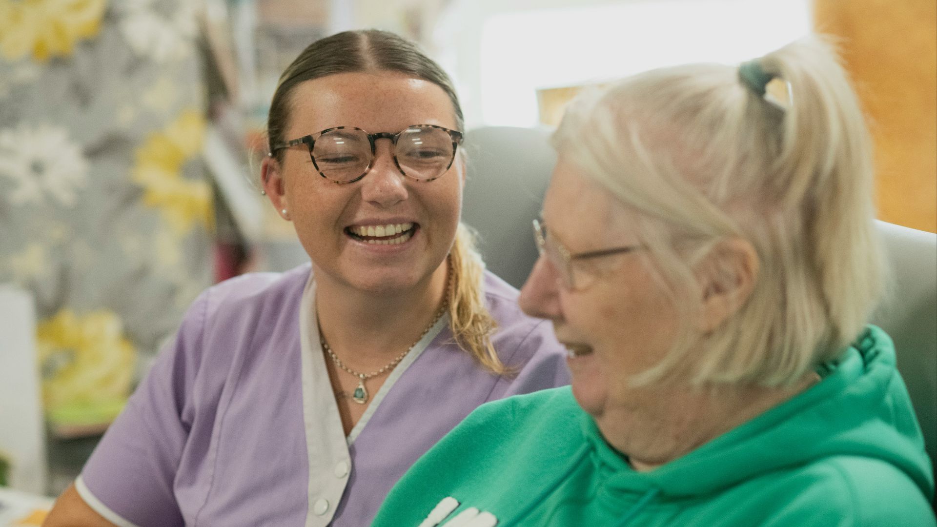 Two women laughing together indoors