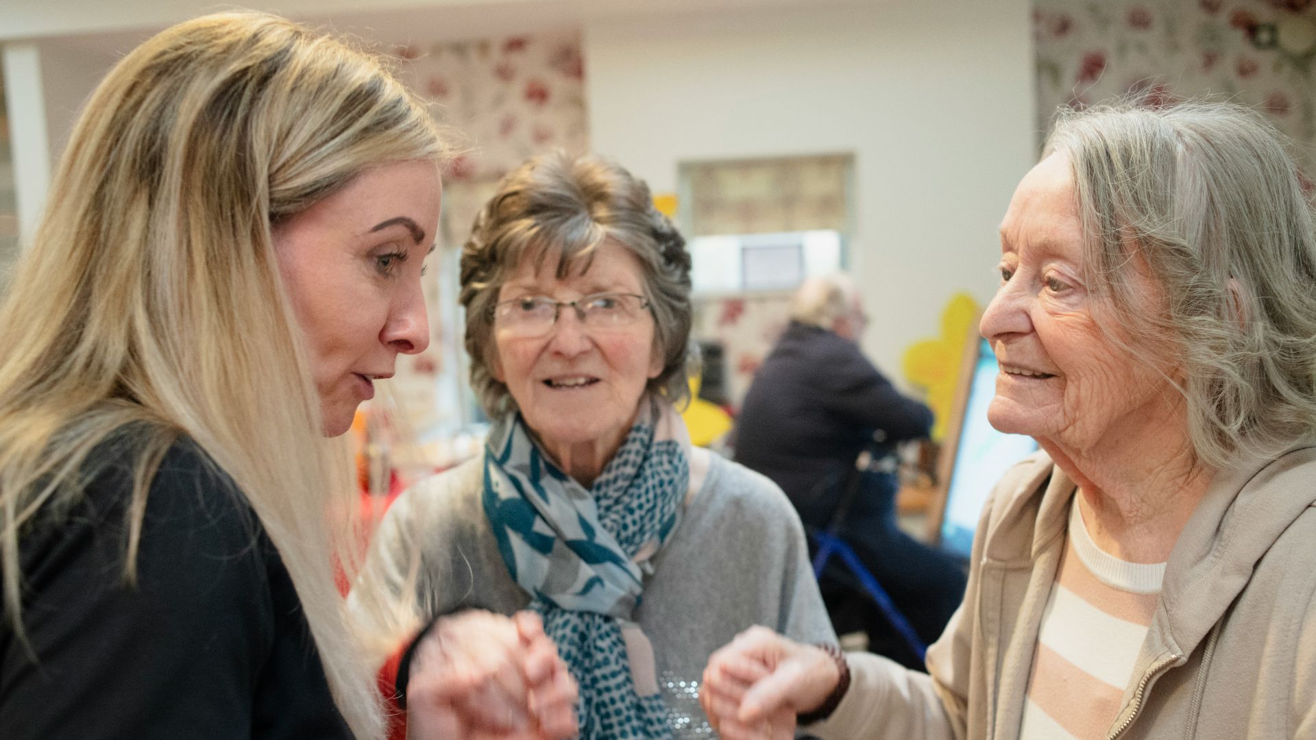 Three women interacting indoors with soft lighting