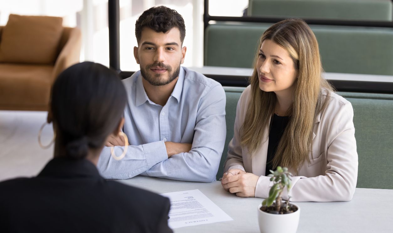 Shutterstock-2649942883, Seeking advice. Attentive family couple clients of bank manager real estate agent broker discuss terms conditions of loan mortgage agreement life insurance policy investment options of buying business