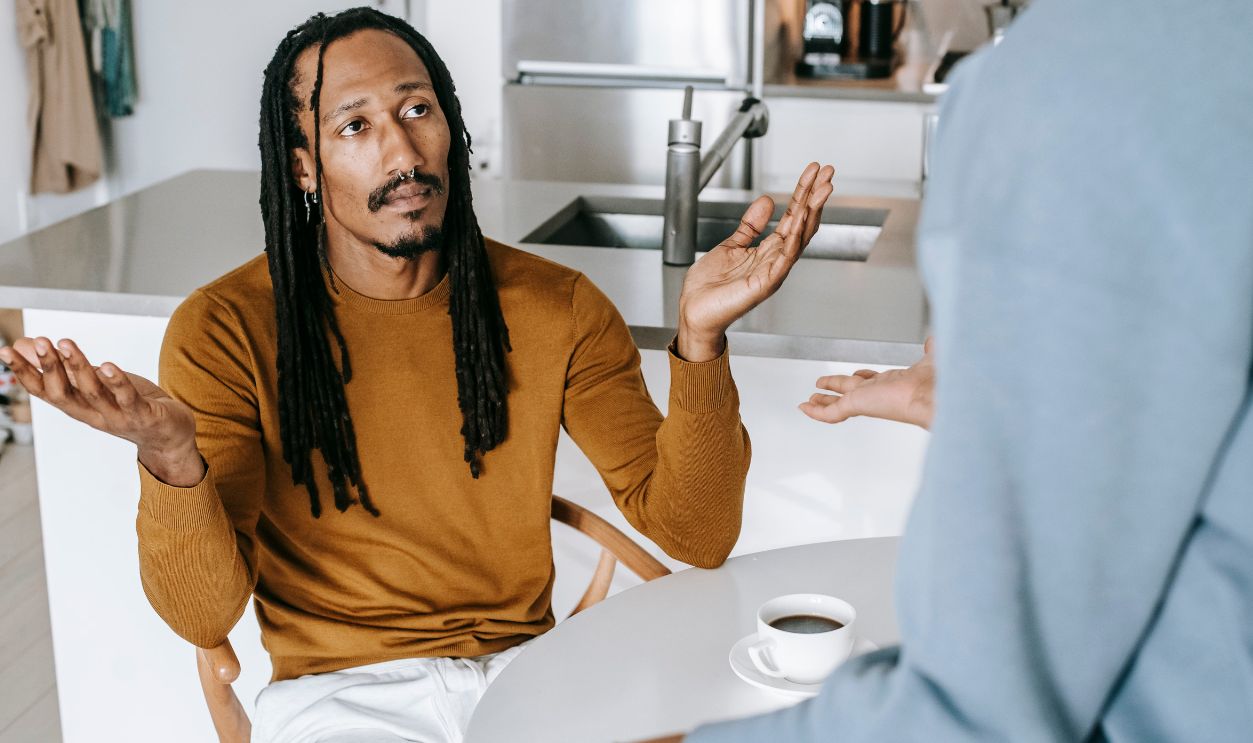 A couple in discussion at a kitchen table, capturing a serious moment in a relationship