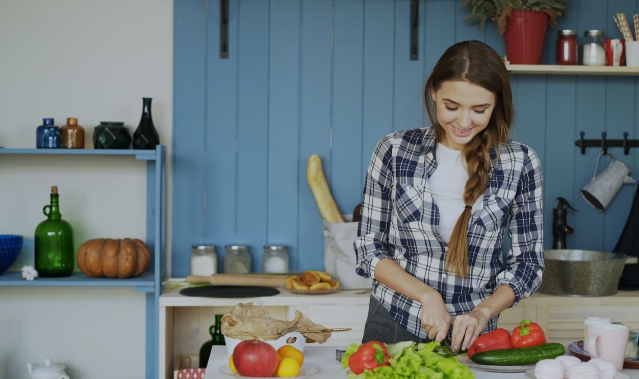 Smiling woman chopping vegetables in a cozy kitchen setting