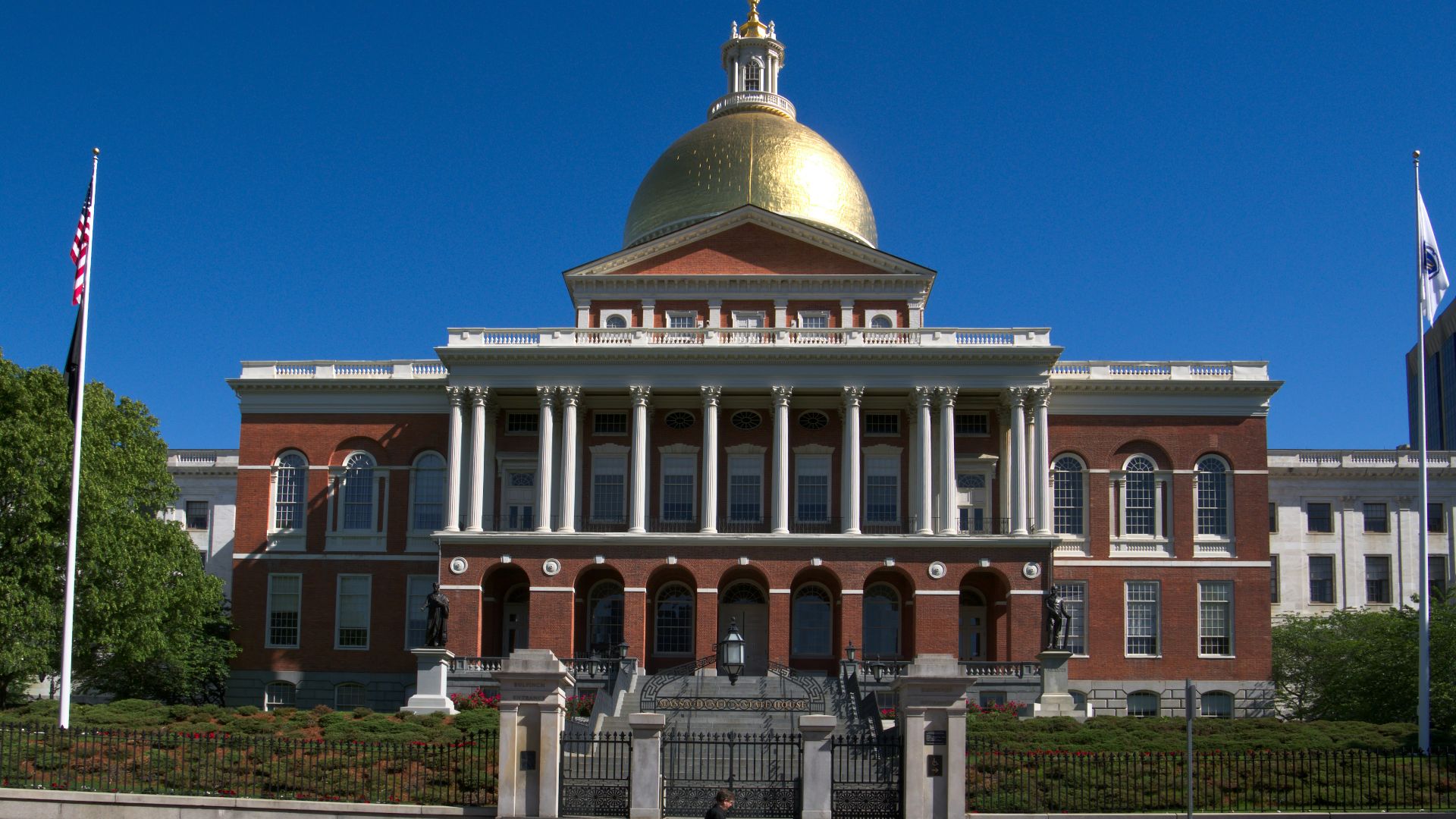 Massachusetts state house with golden dome and flags