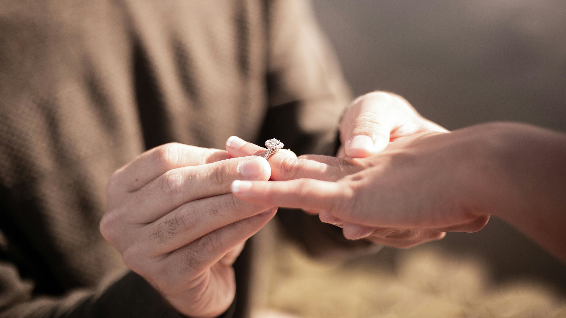 person holding silver diamond ring