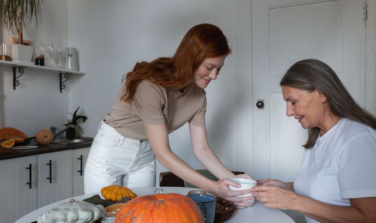 A young woman and her mother enjoy a meal together at their cozy kitchen table
