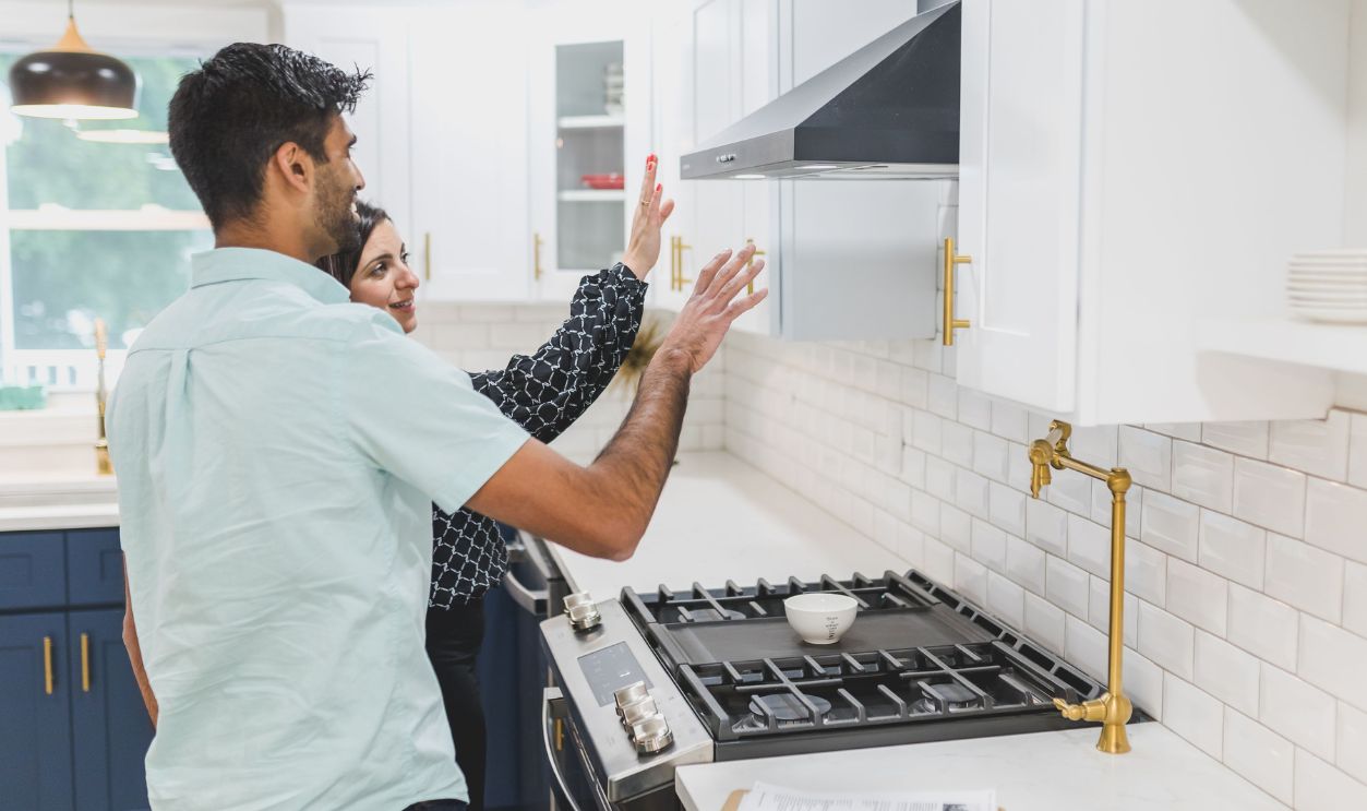 A real estate agent demonstrates kitchen features in a modern home. Ideal for real estate and lifestyle concepts