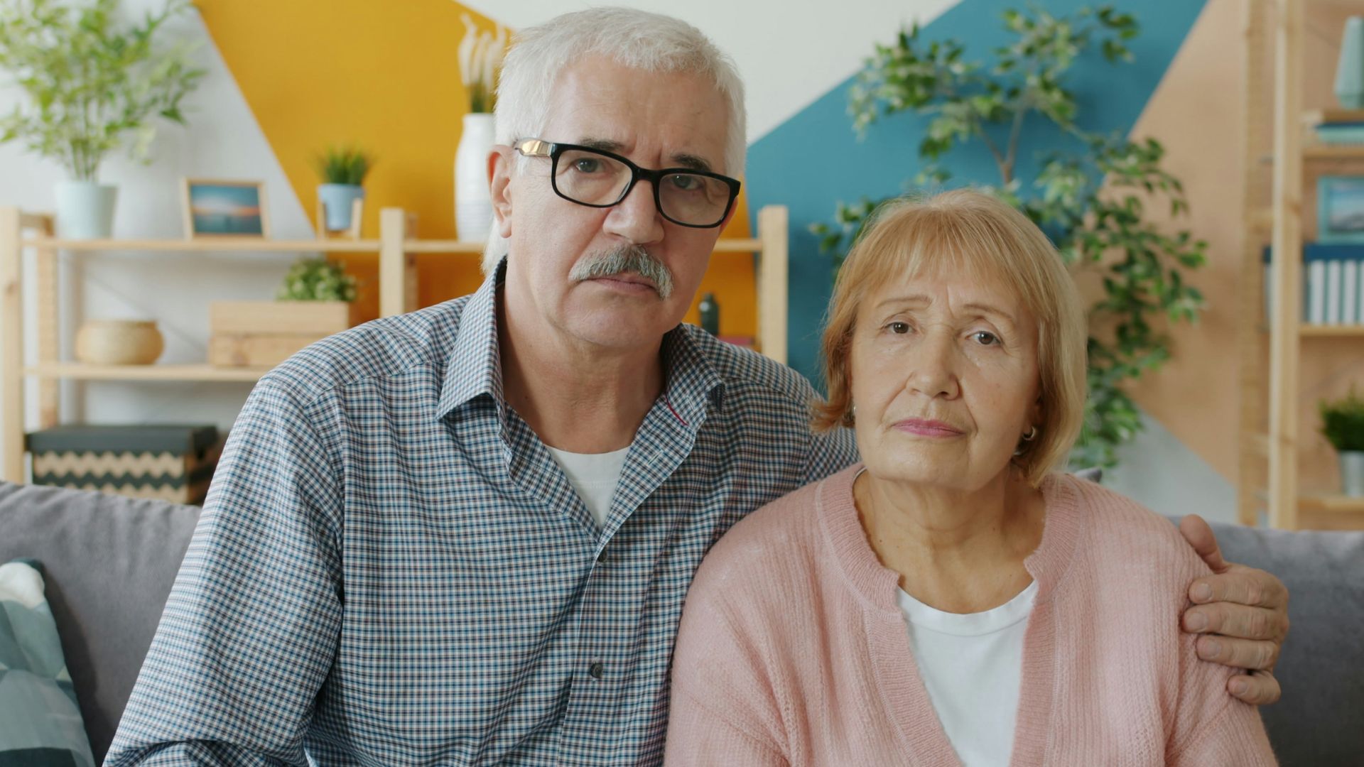 Elderly couple sitting on a couch indoors