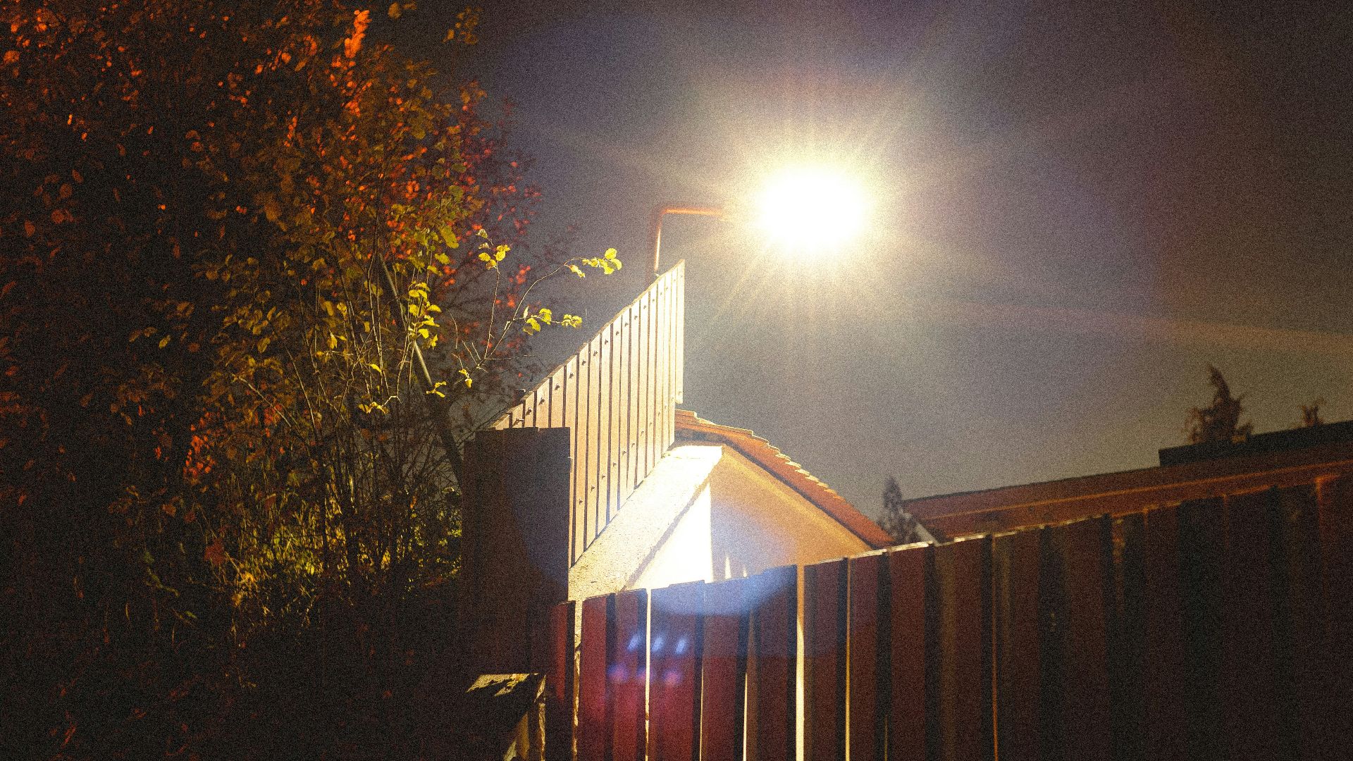 a street light shines brightly on a dark night
