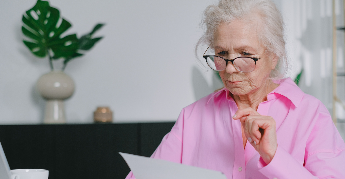 an-elderly-woman-in-pink-long-sleeves-looking-at-documents-while-sitting
