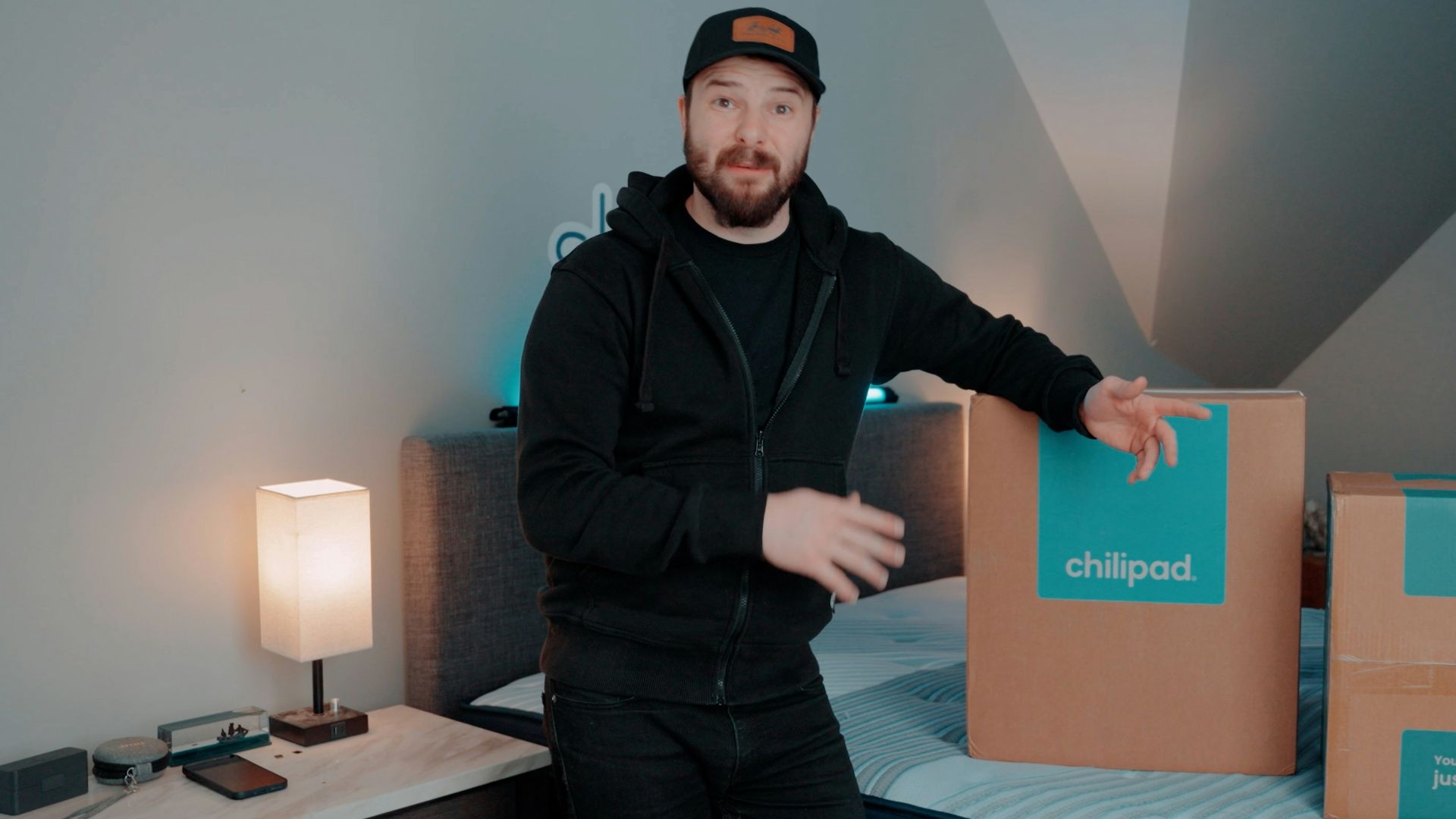 Man standing next to two delivery boxes on a bed