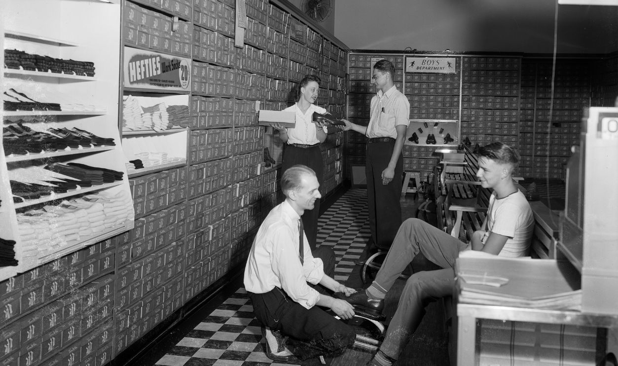 Clerks help customers try on shoes at the Thom McAn Shoe Store, 224 State Street, Madison, Wisconsin, August 16, 1944