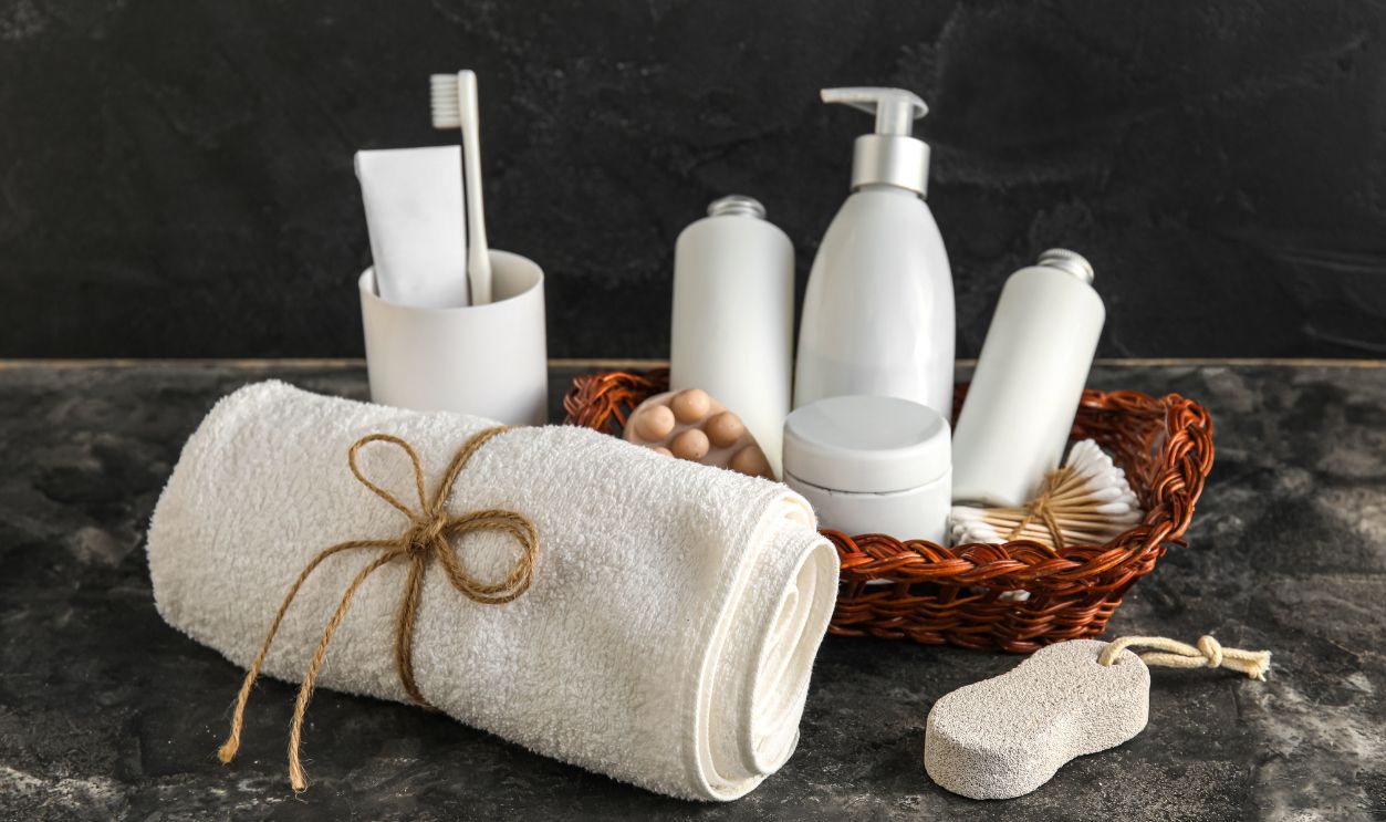 Shutterstock - 2403079085 - Set of bath supplies with towel on dark background.