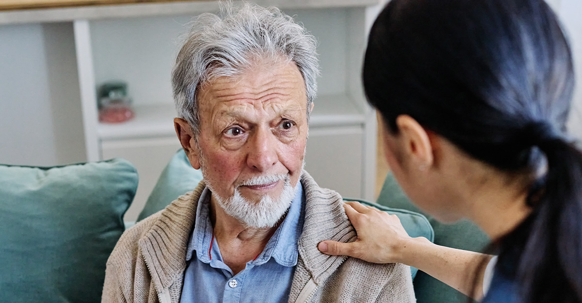 Doctor or nurse caregiver's hand giving support to sad lonely senior man at home or nursing home