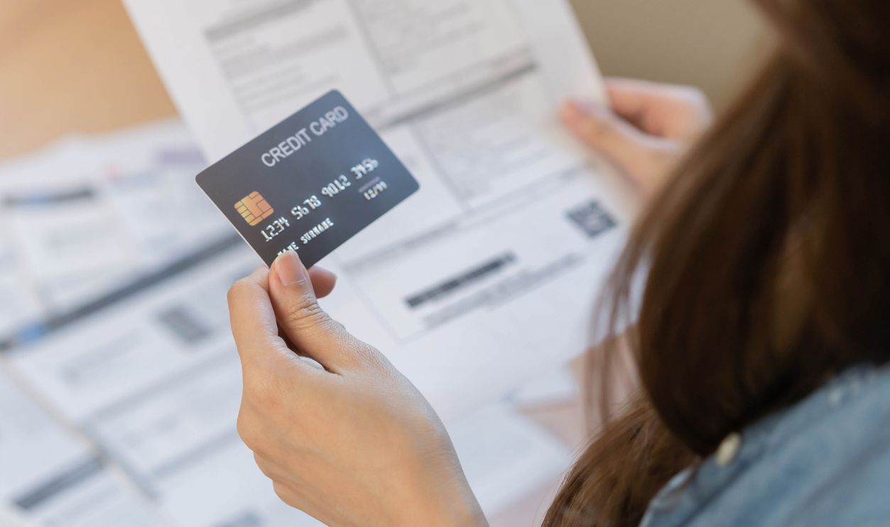 Shutterstock-2152500689, Financial owe asian young woman, girl sitting suffer, stressed and confused, hand in holding credit card, no money to pay expense, mortgage or loan. Debt, bankruptcy or bankruptcy concept.