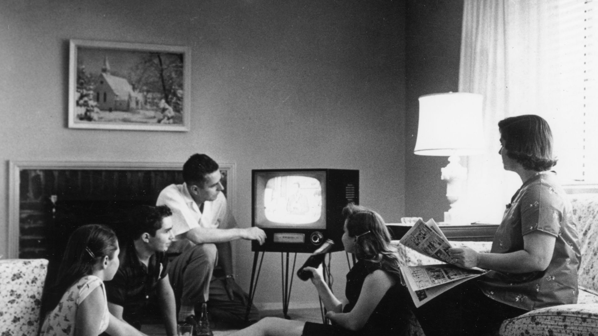 Family watching television in their home, c. 1958