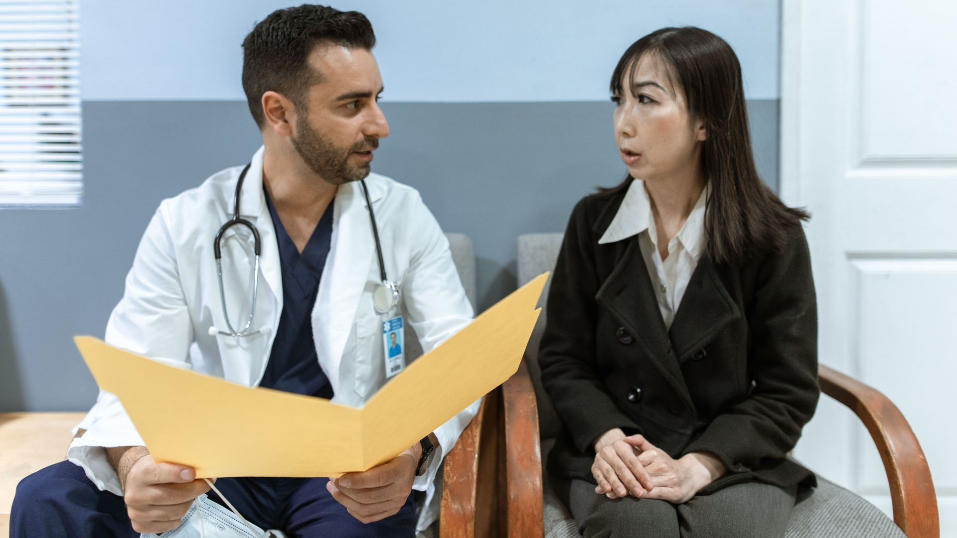 Healthcare professional consults patient in clinical setting. Medical discussion and diagnosis.