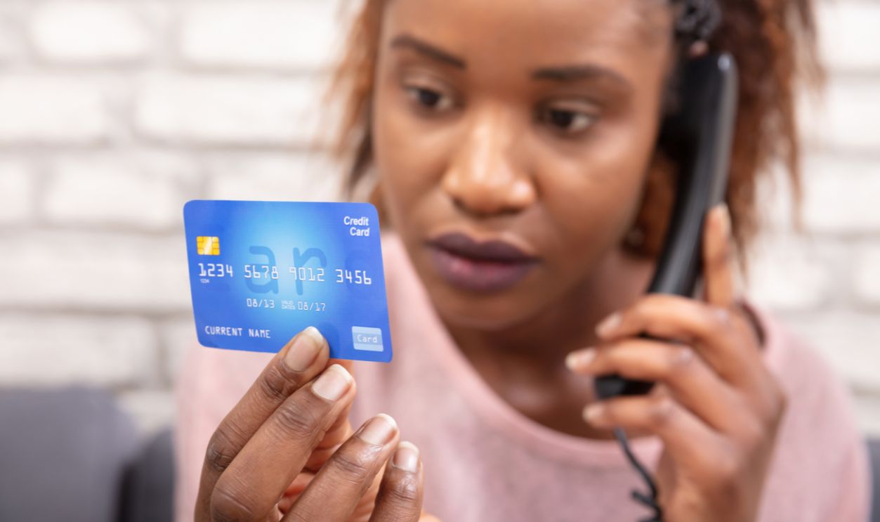 Close-up Of A African Woman With Credit Card Using Landline Phone
