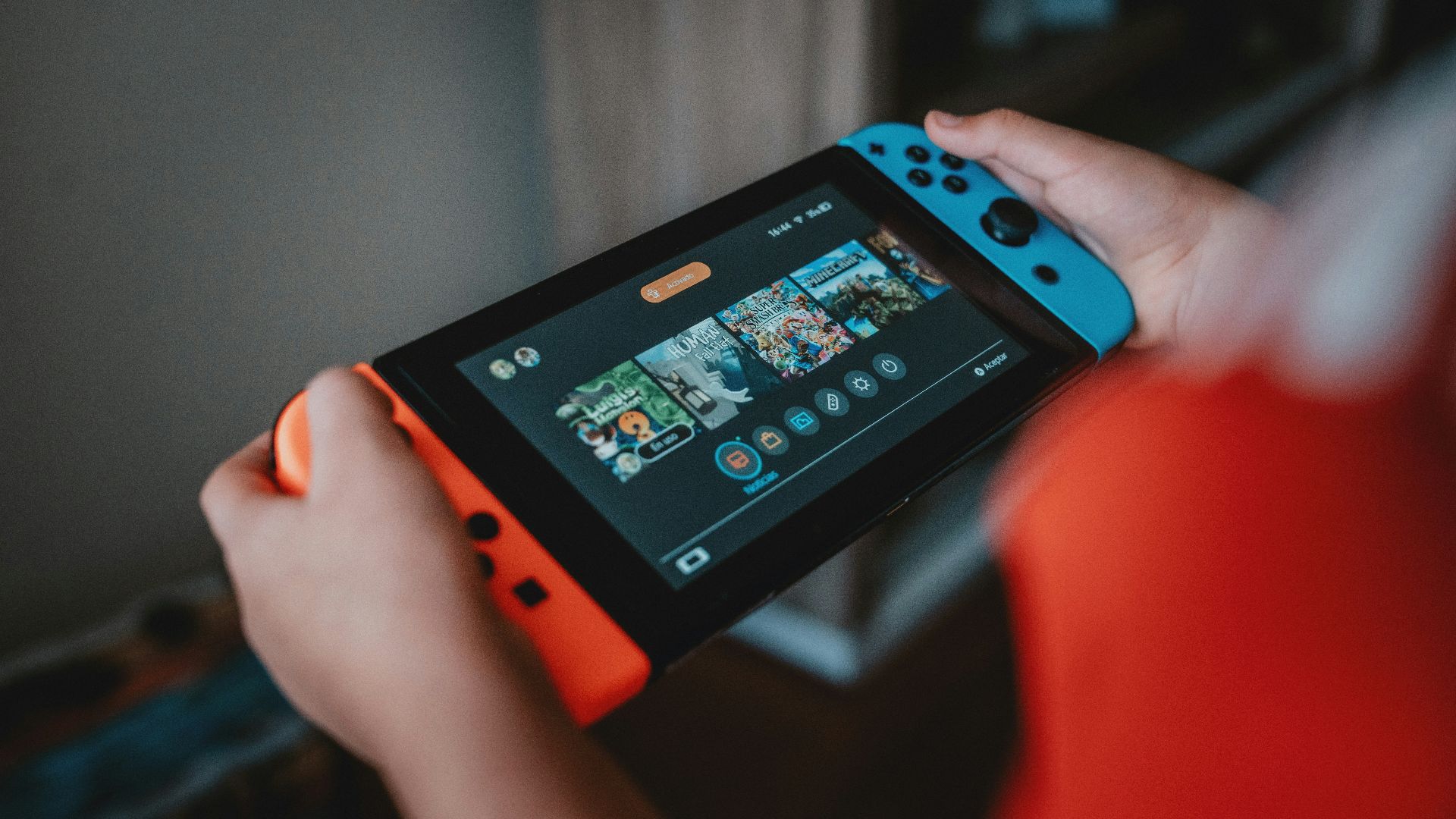 person holding black and orange nintendo switch