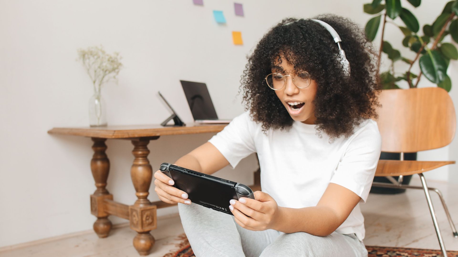 Woman enjoying video game on handheld console indoors, casual setting.