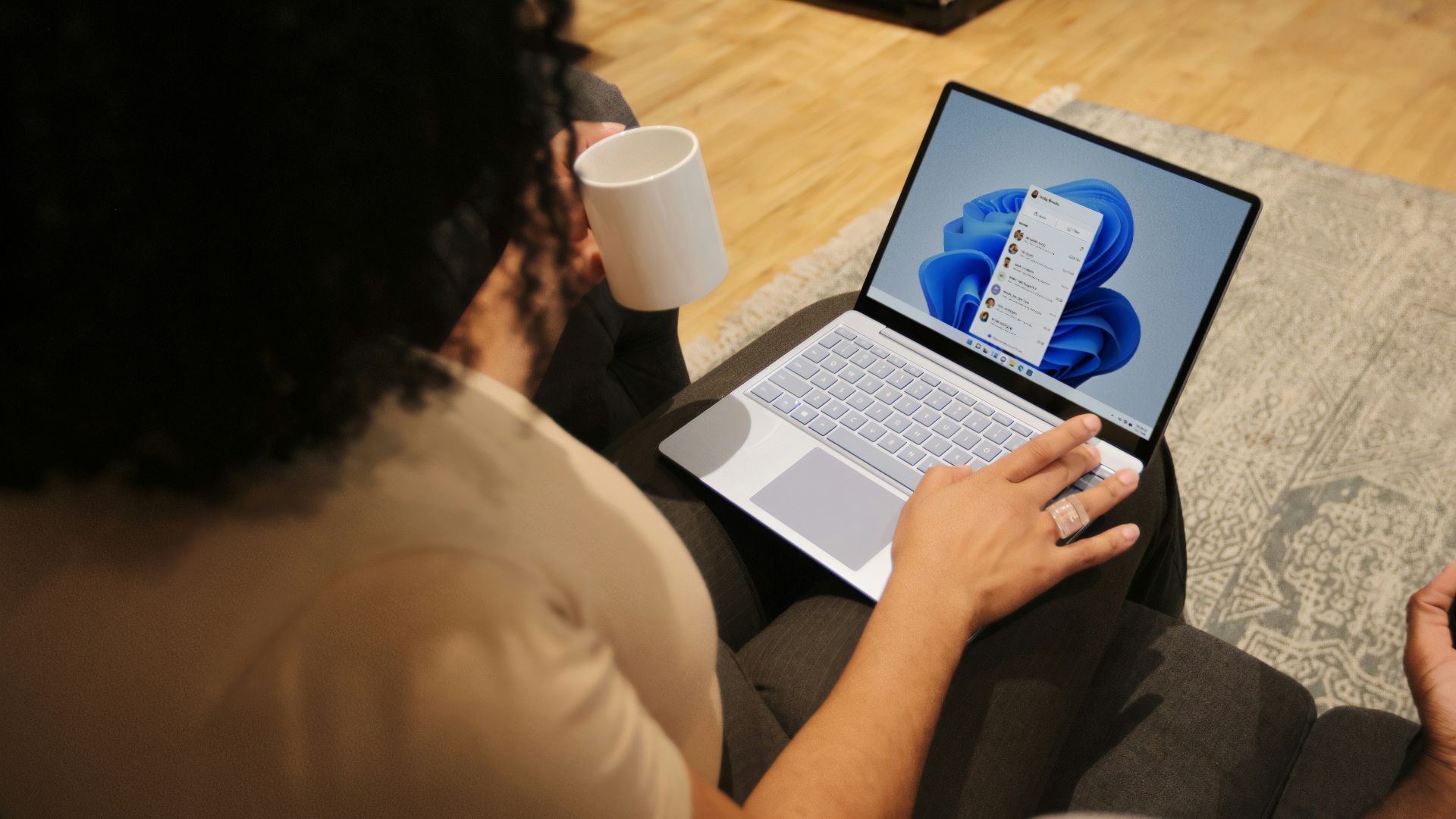 Female on her Microsoft laptop at work drinking coffee