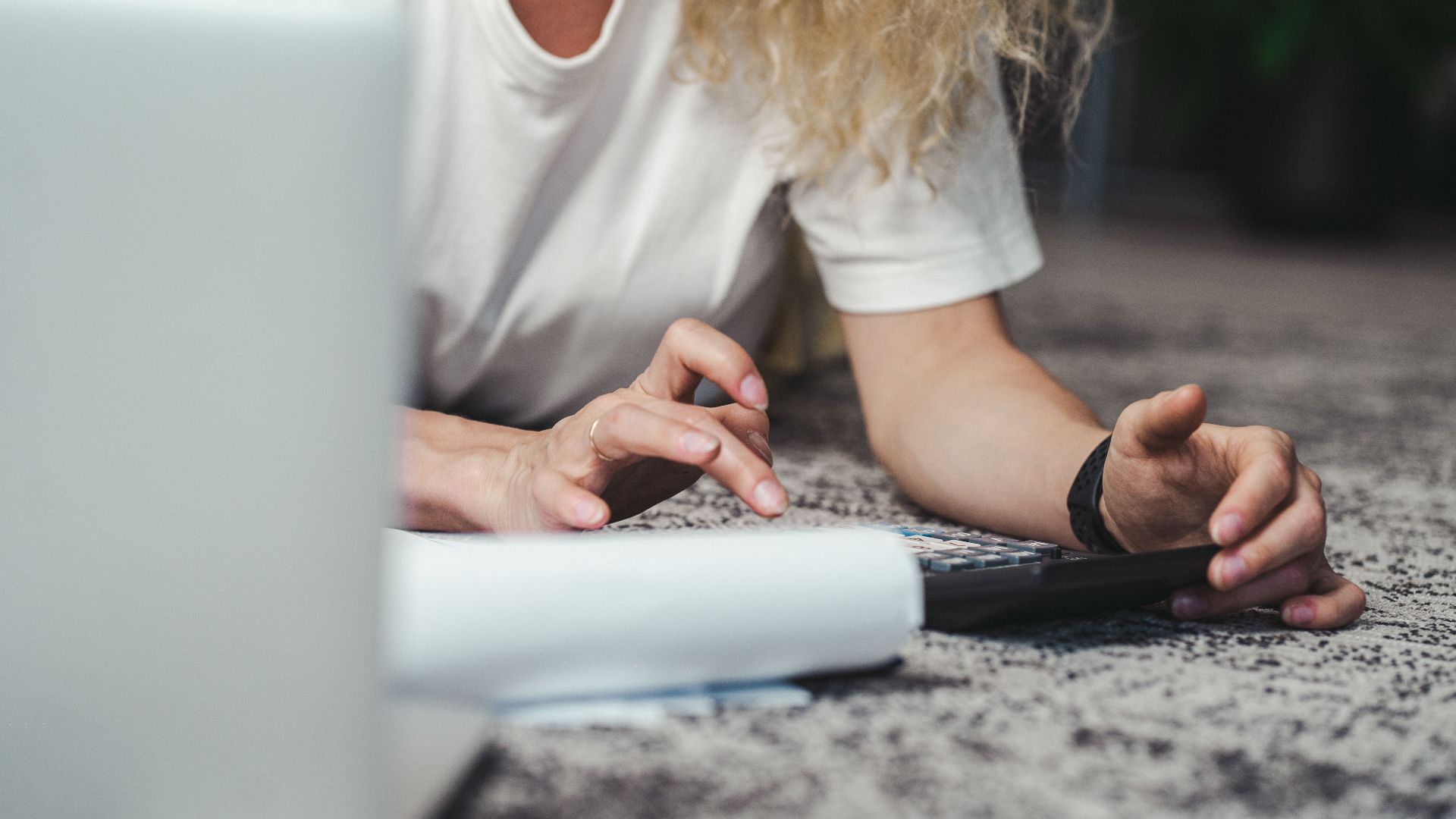 A woman engages in budget planning using a calculator on a comfortable carpeted floor.