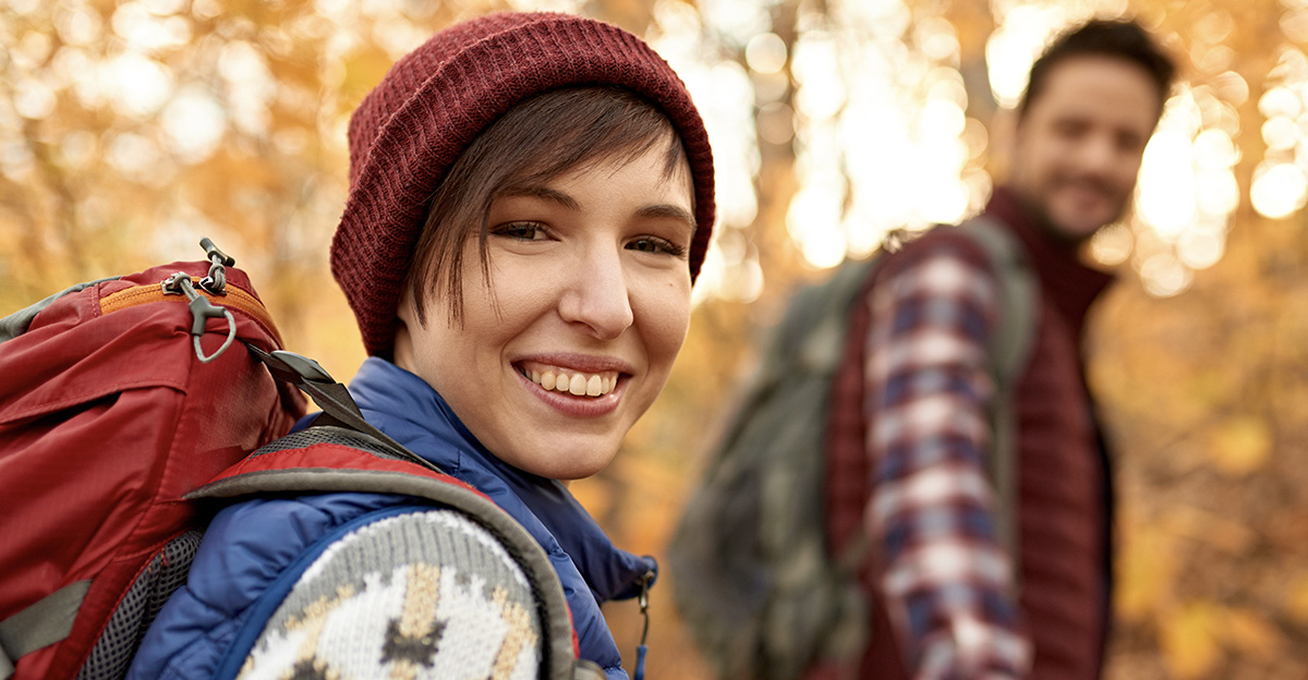 Attractive caucasian couple hiking through the forest in the fall in Canada