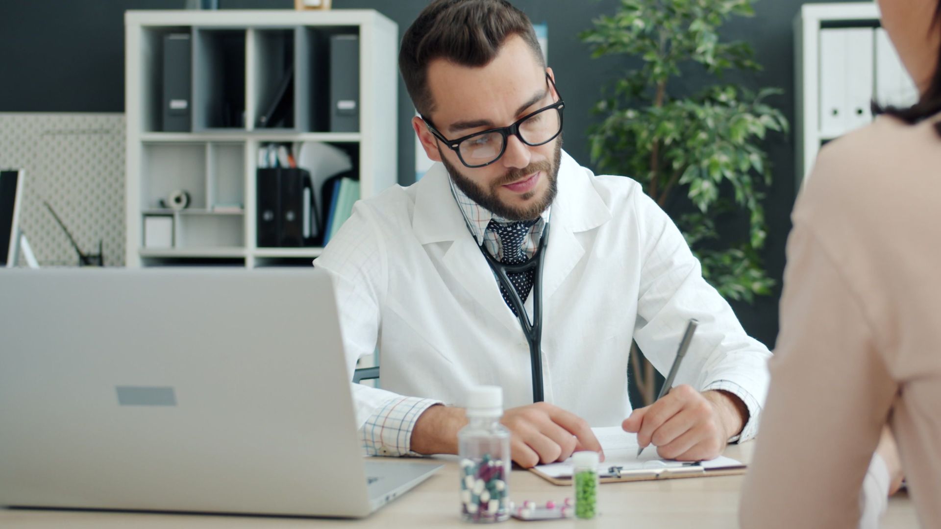 Doctor in white coat consulting patient in a modern office setting.