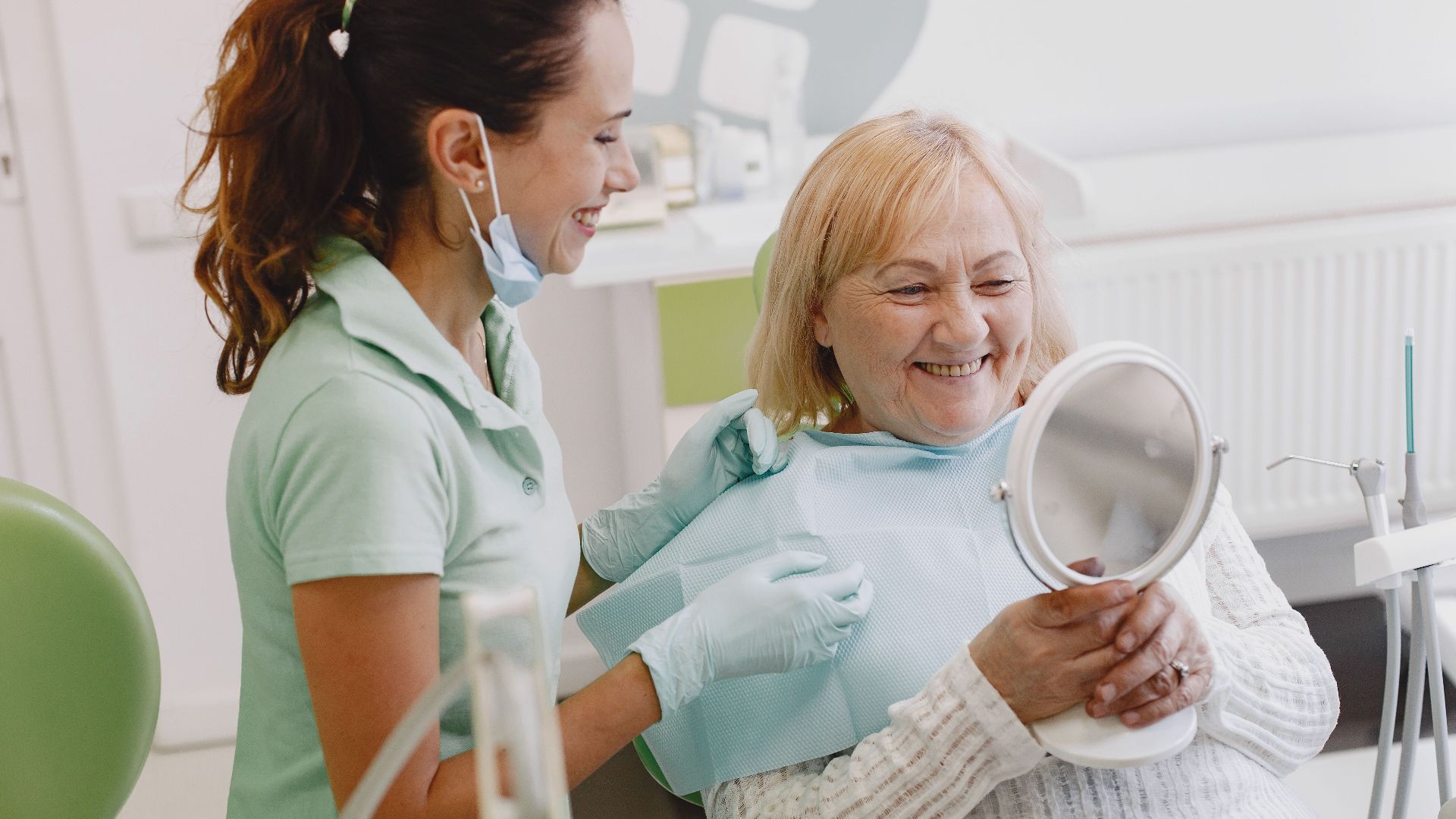 Senior patient at a dental check-up, smiling with the dentist in a modern clinic.