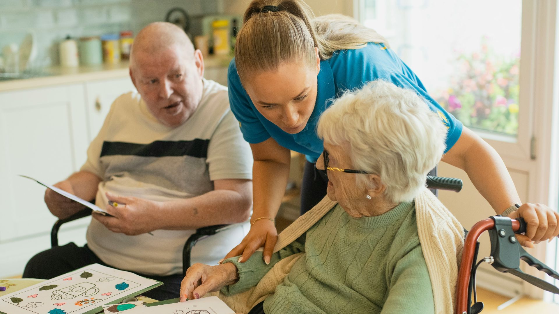 Caregiver assisting elderly couple with coloring