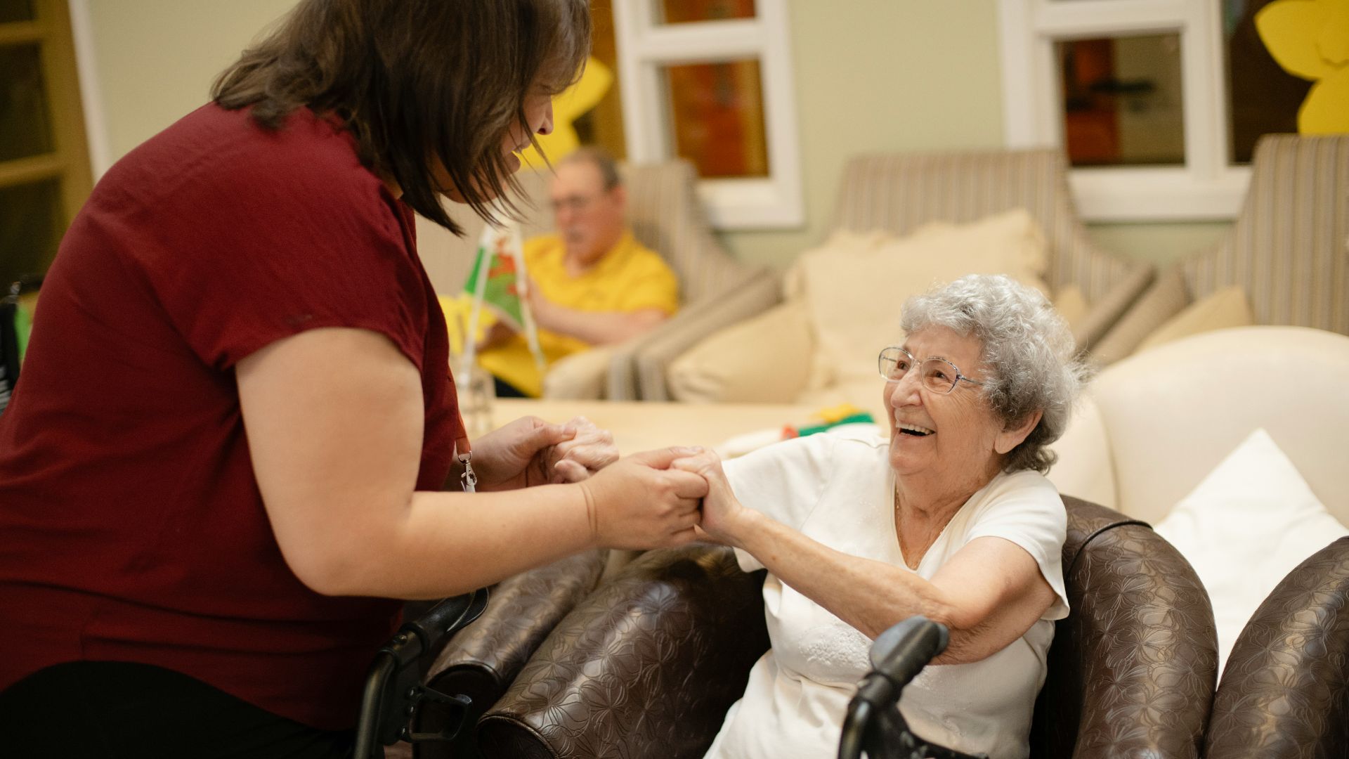 Caregiver assists elderly woman with walker