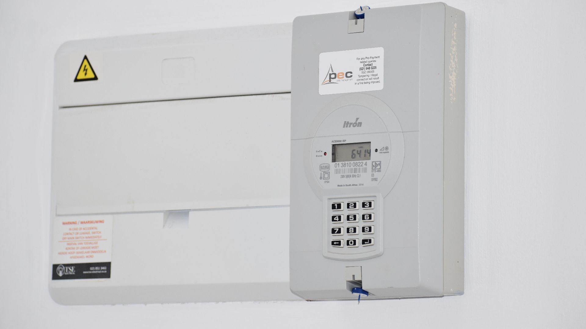 Electrical meter and fuse box on a white wall in Cape Town, South Africa, for energy monitoring or billing.