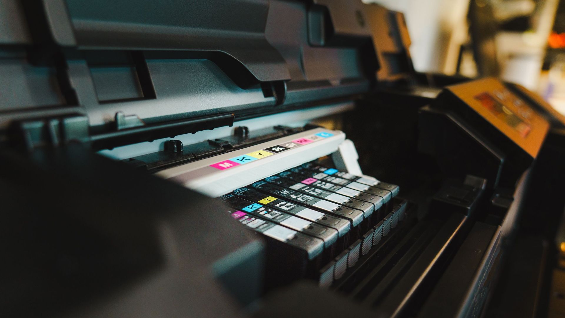 Detailed view of ink cartridges inside a digital inkjet printer in an office setting.