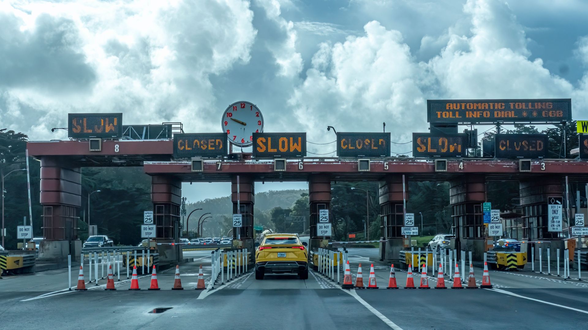 View of vehicles approaching the toll plaza at Golden Gate Bridge in San Francisco under a cloudy sky.
