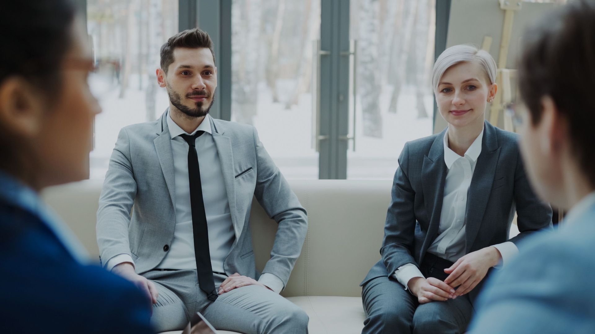Business meeting with professionals in suits discussing in a modern office.
