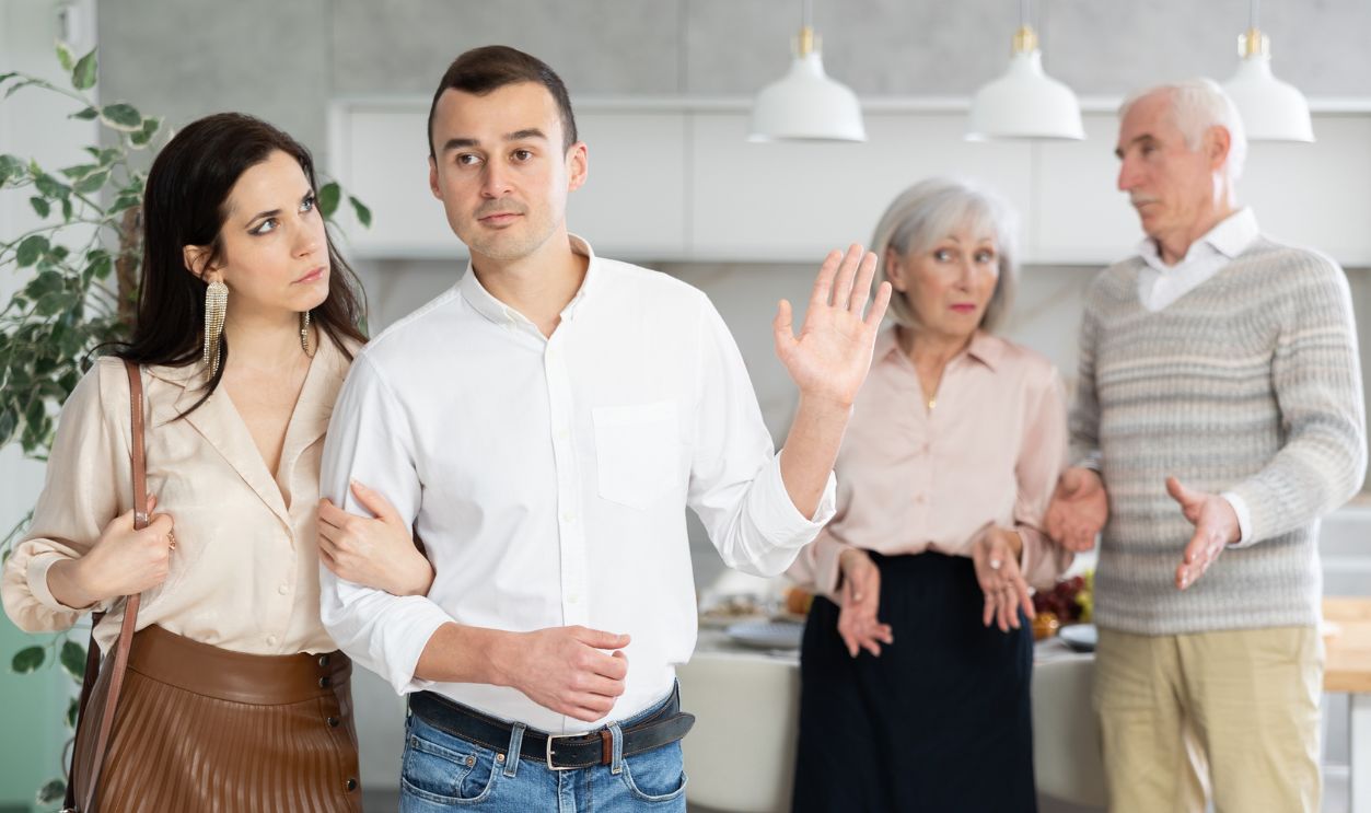 Shutterstock - 2745433517 - Grumpy pensioners scold adult son and his girlfriend, argue and insult young married couple after family gatherings. Concept of annoying misunderstandings in family relationships.