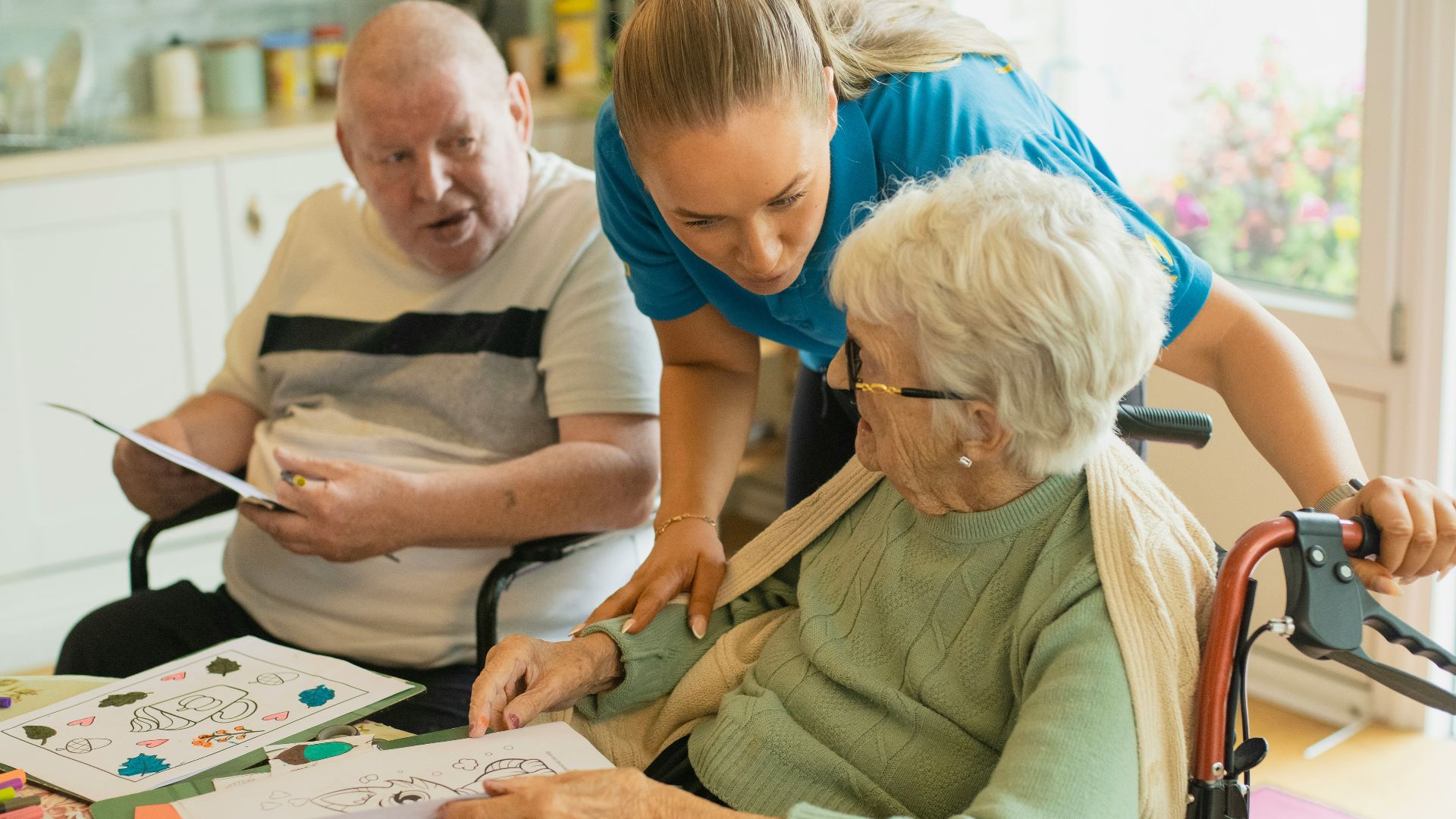 Caregiver assisting elderly couple with coloring