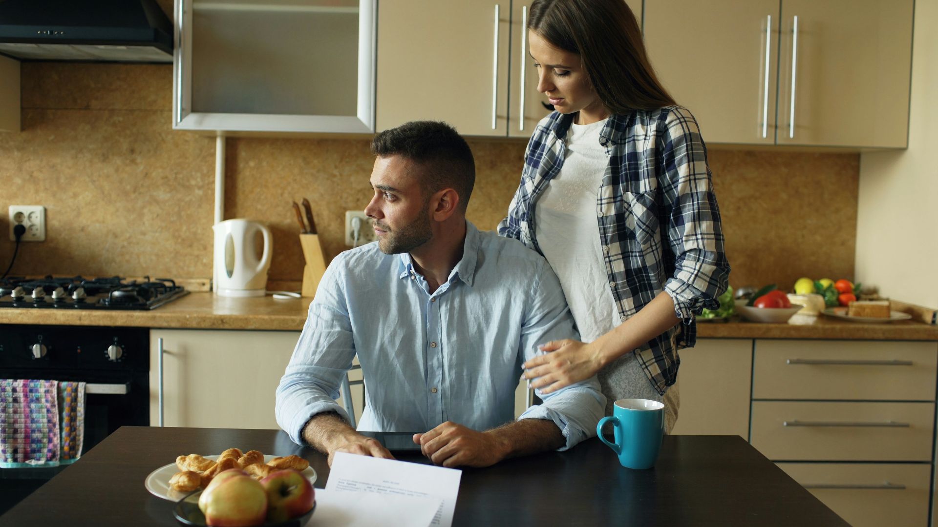 Couple sitting at kitchen table with pastries